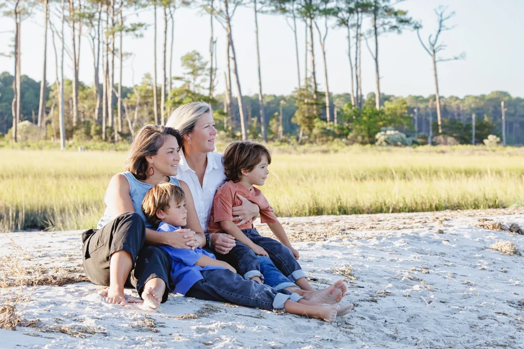 Family sitting on the dunes at Cape Henlopen State Park during golden hour